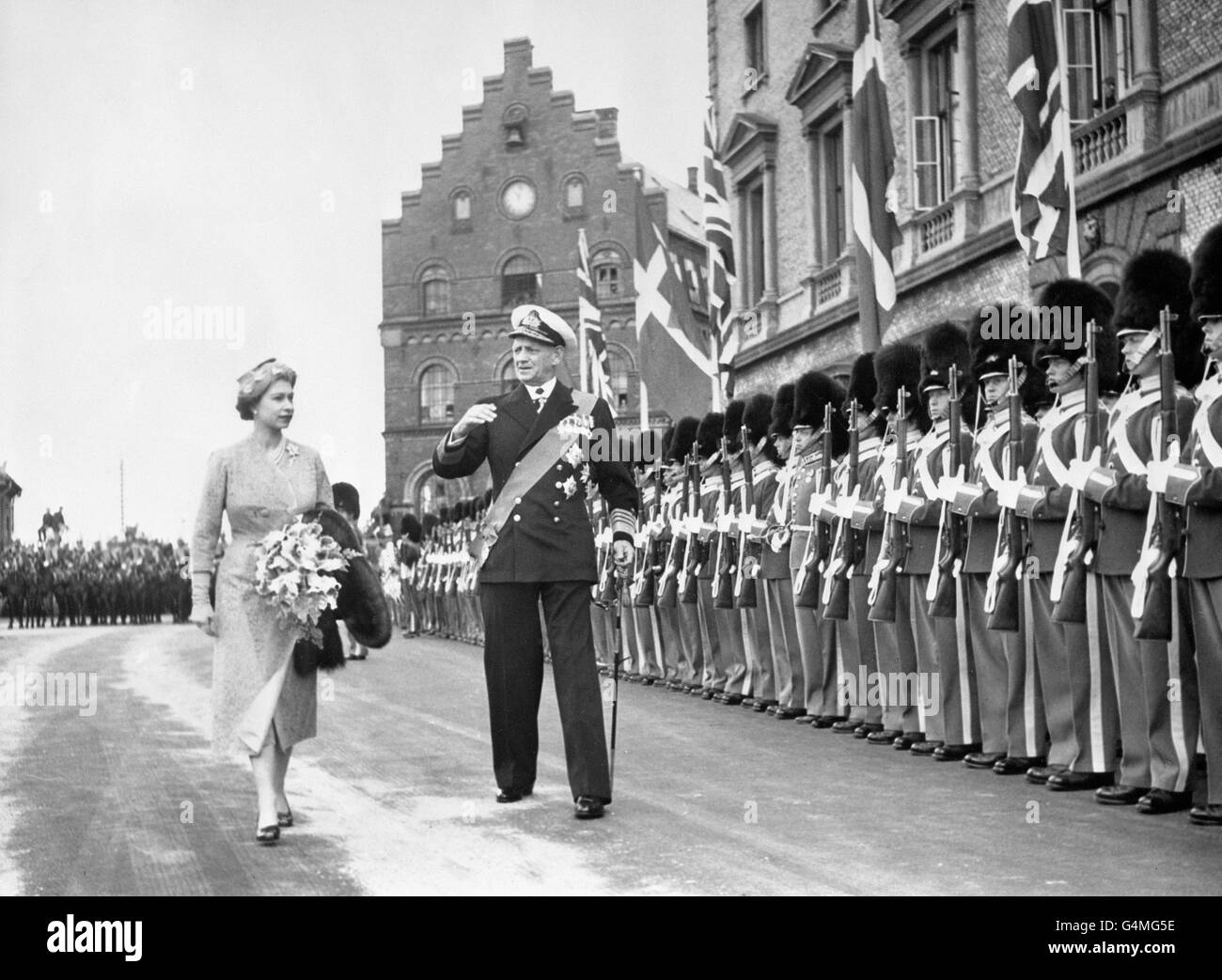 Die Ehrengarde präsentiert Waffen, als Königin Elizabeth II. Mit König Frederik IX. Von Dänemark bei ihrer Ankunft mit dem Herzog von Edinburgh in Kopenhagen vorbeigeht. Stockfoto