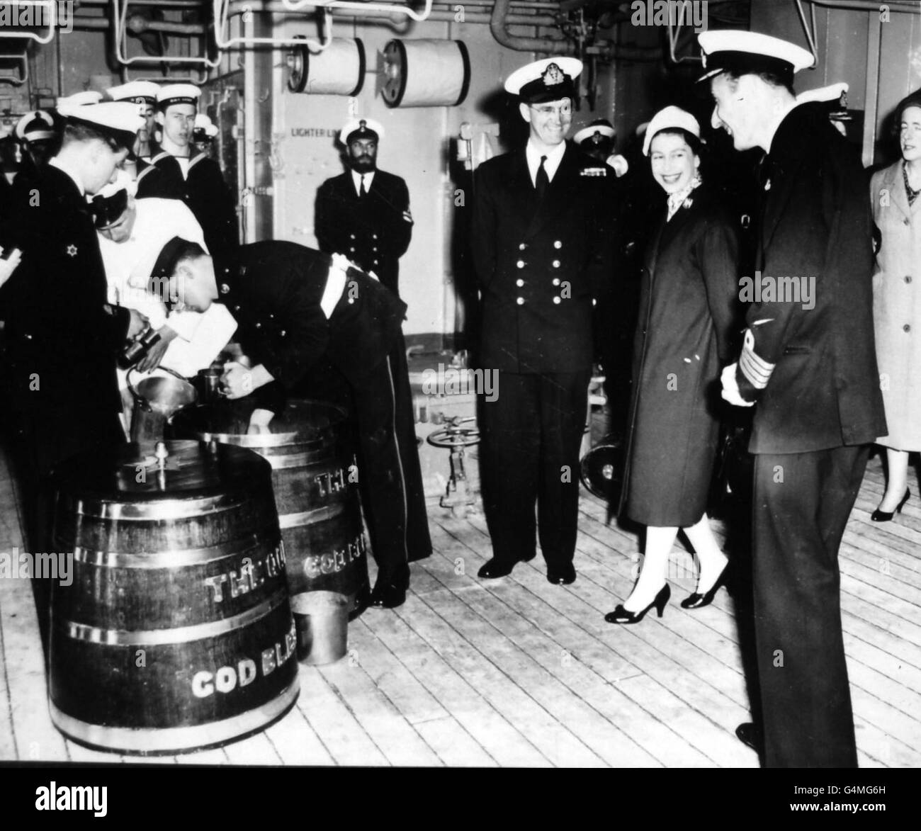 Königin Elizabeth II lächelt mit den Offizieren, als sie die traditionelle Rum-Ausgabe an Bord des Flugzeugträgers Eagle vor Weymouth, Dorset, beobachtet. Stockfoto