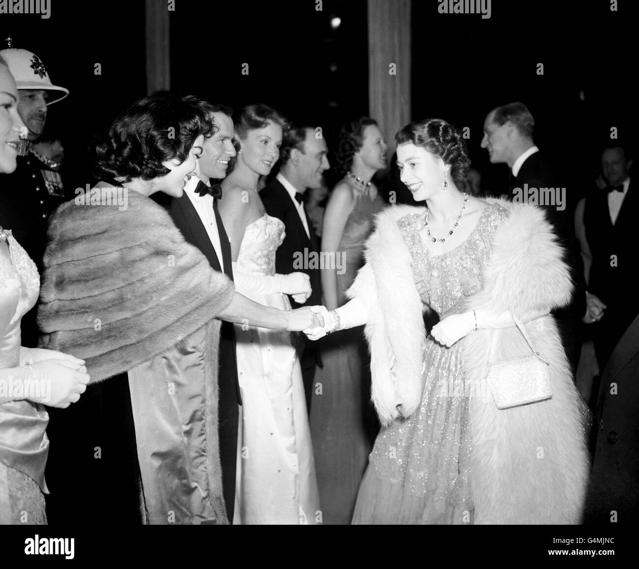 Prinzessin Elizabeth schüttelt sich die Hände mit der amerikanischen Schauspielerin Ava Gardner. Der nächste in der Reihe ist Ava's Ehemann, Sänger Frank Sinatra. Sie nahmen an der Midnight Matinee Show im London Coliseum Teil. Stockfoto