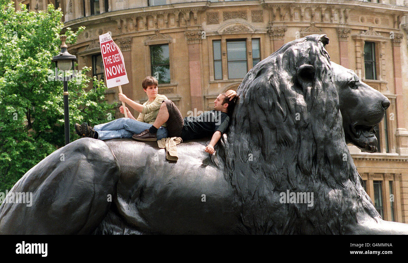 Zwei Unterstützer von Jubilee 2000 ruhen auf dem Rücken eines Löwen auf dem Trafalgar Square im Zentrum Londons. Christian Aid organisierte eine Open-Air-Veranstaltung, um die Annullierung der Schulden der Dritten Welt zu fordern. Stockfoto