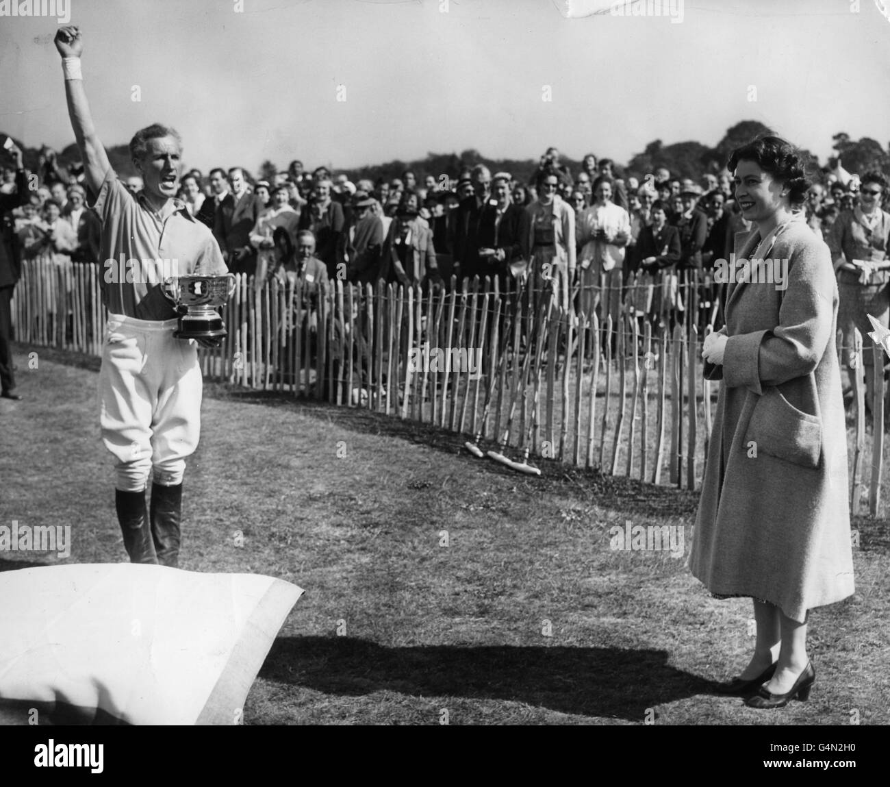 *abgescannt* Brigadier Masood Ali Baig ruft nach drei Jubelrufen für die Königin, die lächelnd zuschaut, nach dem Einladungs-Polospiel, in dem Cowdray Park das Windsor Park Team besiegte, angeführt vom Duke of Edinburgh, in Smith's Lawn, Windsor Great Park. Stockfoto