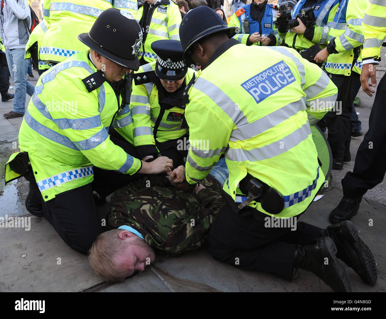 Die Polizei entnimmt Demonstranten, die während des letzten studentendemarsches am Trafalgar Square in London ein Lager eingerichtet hatten. Stockfoto