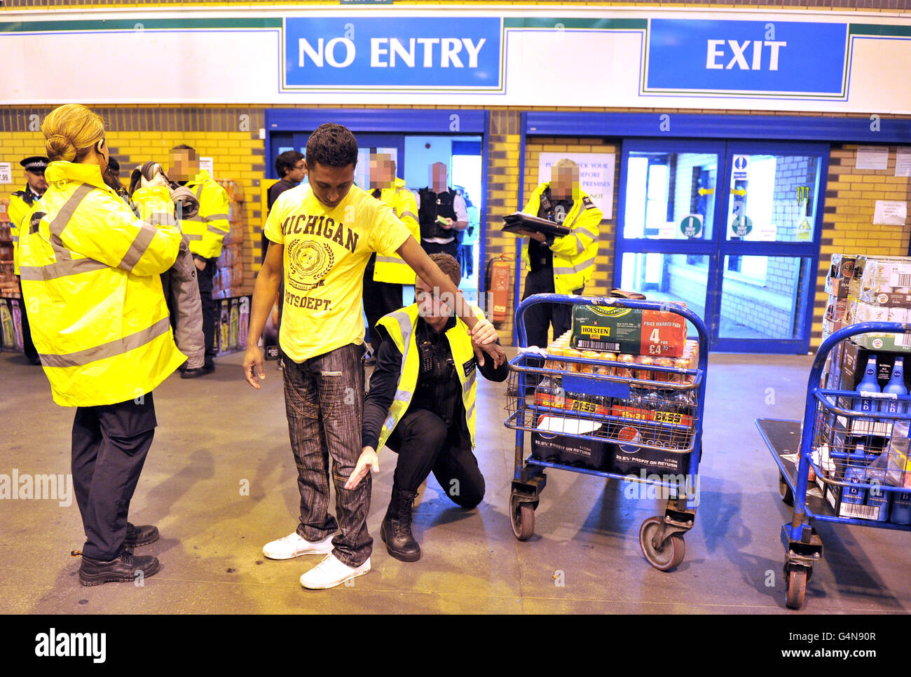 EDITORS NOTE GESICHTER VON PA-BILDTISCH VERPIXELT EIN Kunde (Name nicht bekannt) von Bestway Cash and Carry in Liverpool wird von Beamten der britischen Grenzbehörde verhaftet. DRÜCKEN SIE VERBANDSFOTO. Bilddatum: Donnerstag, 10. November 2011. Zwei illegale Einwanderer wurden festgehalten, als Beamte der Grenzbehörde das Stadtzentrum mit Bargeld überfielen. Es wurde festgestellt, dass ein pakistanischer Mann im Alter von 22 Jahren und ein 22-jähriger Iraker illegal arbeiten. Es wird erwartet, dass die beiden abgeschoben werden. Siehe PA Geschichte POLIZEI RAID. Bildnachweis sollte lauten: Martin Rickett/PA Wire Stockfoto