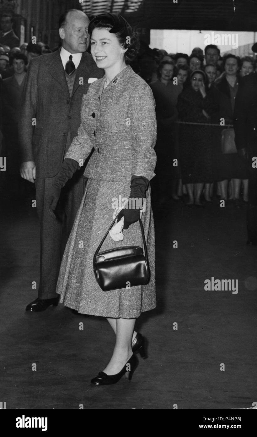 Königin Elizabeth II. Trägt ihren Schal, als sie an Bord eines Zuges nach Cheltenham in Paddington Station, London, geht. Stockfoto