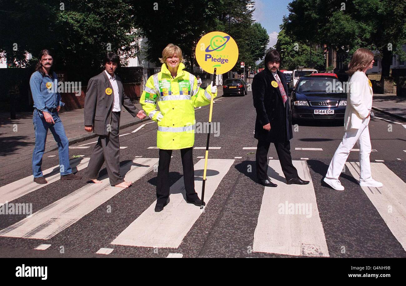 Die Fernsehmoderatorin Anthea Turner, die als Lollipop-Dame verkleidet ist, hilft den Cavern Beatles, das berühmte Beatles-Albumcover Abbey Road in London nachzubauen, wo sie Planet Pledge 2000 promotete. * Planet Pledge ist eine Partnerschaft der Tidy Britain Group, des National Federation of Women's Institute und des Earth Center, die von der Going for Green Charity organisiert wird und auf Recycling und Umweltbewusstsein ausgerichtet ist. Indem sie ihre Botschaft auf den Rücken von Lollipop-Männern und -Frauen platzieren, hoffen sie, Fußgänger und Autofahrer zu erreichen und sie zu drängen, ein Versprechen zu machen, zum Schutz der Umwelt beizutragen. Stockfoto