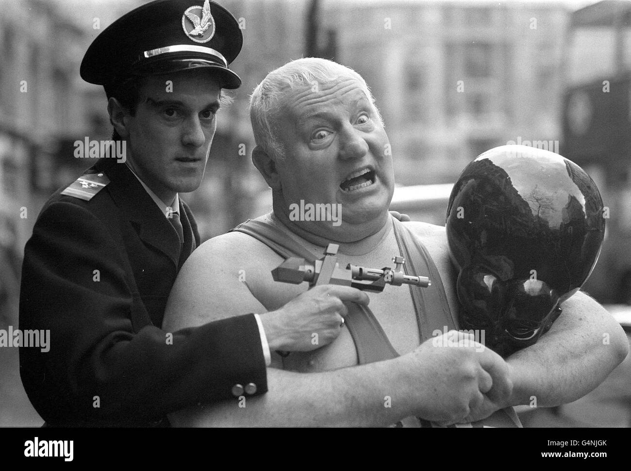 Der britische Superschwergewicht-Wrestler „Big Dadly“ (richtiger Name Shirley Crabtree) spannt eine Armlehne auf Meken, einen furchteinflößenden Eindringling von Venus, der von „Dan Dare“ (dargestellt von Tony Kelleher) beim Start des neuen Eagle-Magazins für junge Menschen durch IPC in London beobachtet wurde. Stockfoto