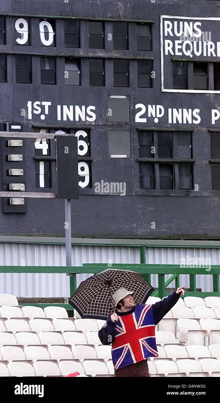 Ein eingefleischter England-Fan schützt sich vor dem Regen unter dem Punktestand in Old Trafford, Manchester, in der vergeblichen Hoffnung auf Spiel am letzten Tag des dritten Tests zwischen England V Neuseeland. Stockfoto