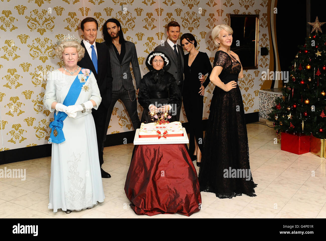 Madame Tussauds veranstaltet eine 250. Geburtstagsparty für ihre Gründerin Madame Marie Tussaud (Mitte) mit Wachsgästen (von links nach rechts), Königin Elizabeth II., Premierminister David Cameron, Russell Brand, David und Victoria Beckham und Helen Mirren im Madame Tussauds in London. Stockfoto