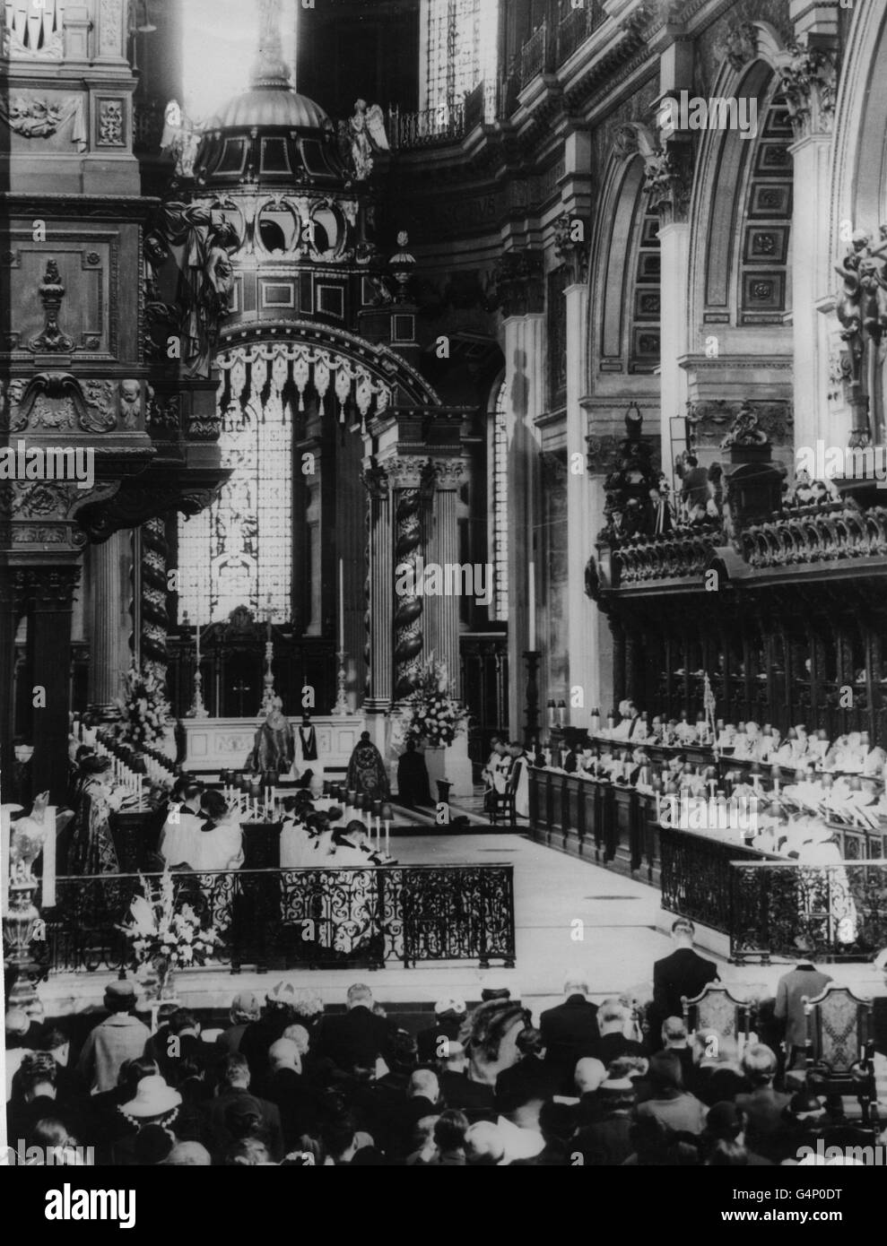 Die Szene in der St. Paul's Cathedral als Erzbischof von Canterbury, Dr. Geoffrey Fisher, segnete während der Wiederweihung des Hochaltars, der bei den Bombenangriffen in London beschädigt wurde. Vor den Altarschienen stehen die Königin und der Herzog von Edinburgh, die im Gebet knieten. Stockfoto