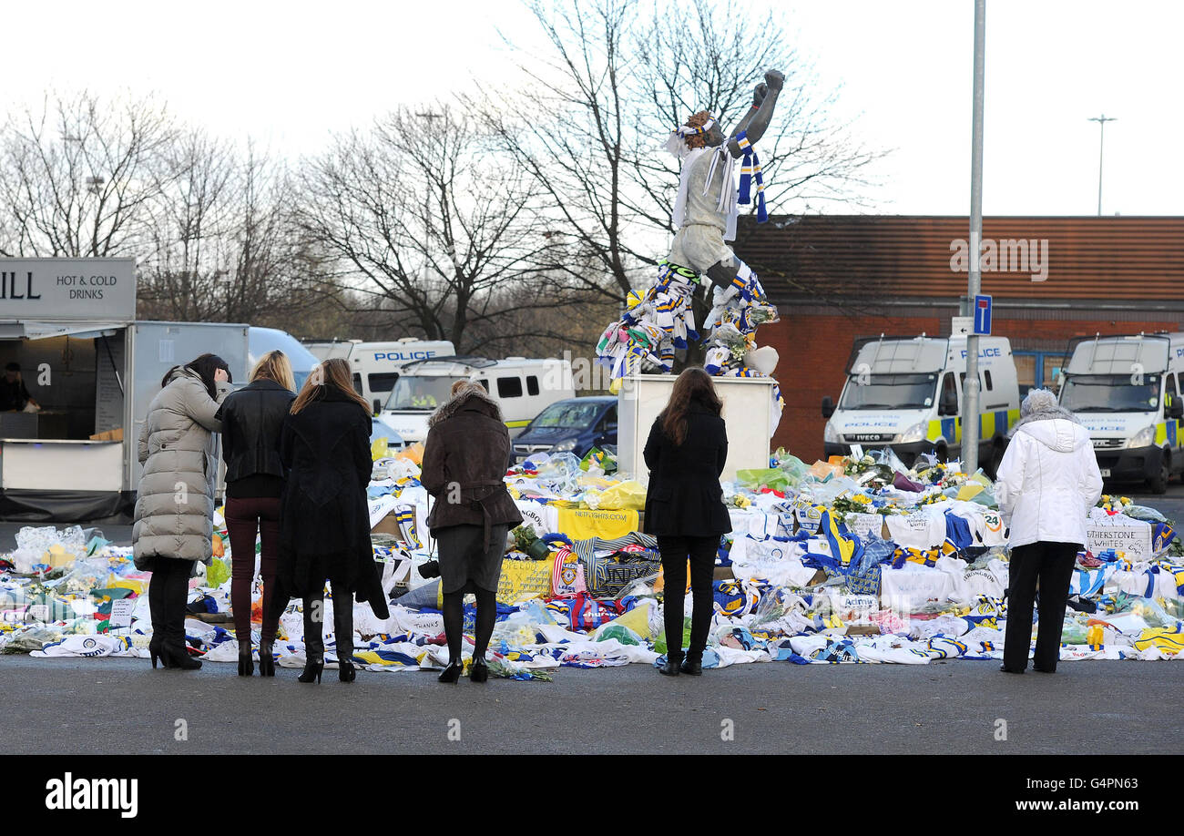 Gary Speeds Familie und Freunde schauen sich Tribute an, die ihm an der Billy Bremer Statue vor dem Leeds United Fußballplatz, Elland Road, hinterlassen wurden. Stockfoto