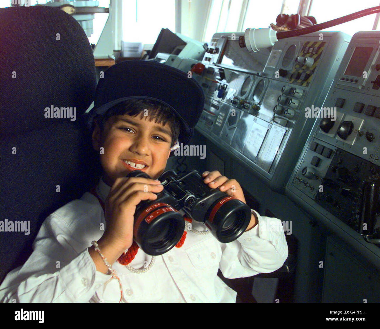 Sieben Jahre altes Kindergenie Nirav Gathani auf der Brücke des Flugzeugträgers HMS Illustrious in Portsmouth. Der junge Student hat Pläne, ein Royal Navy Kapitän zu werden. Stockfoto