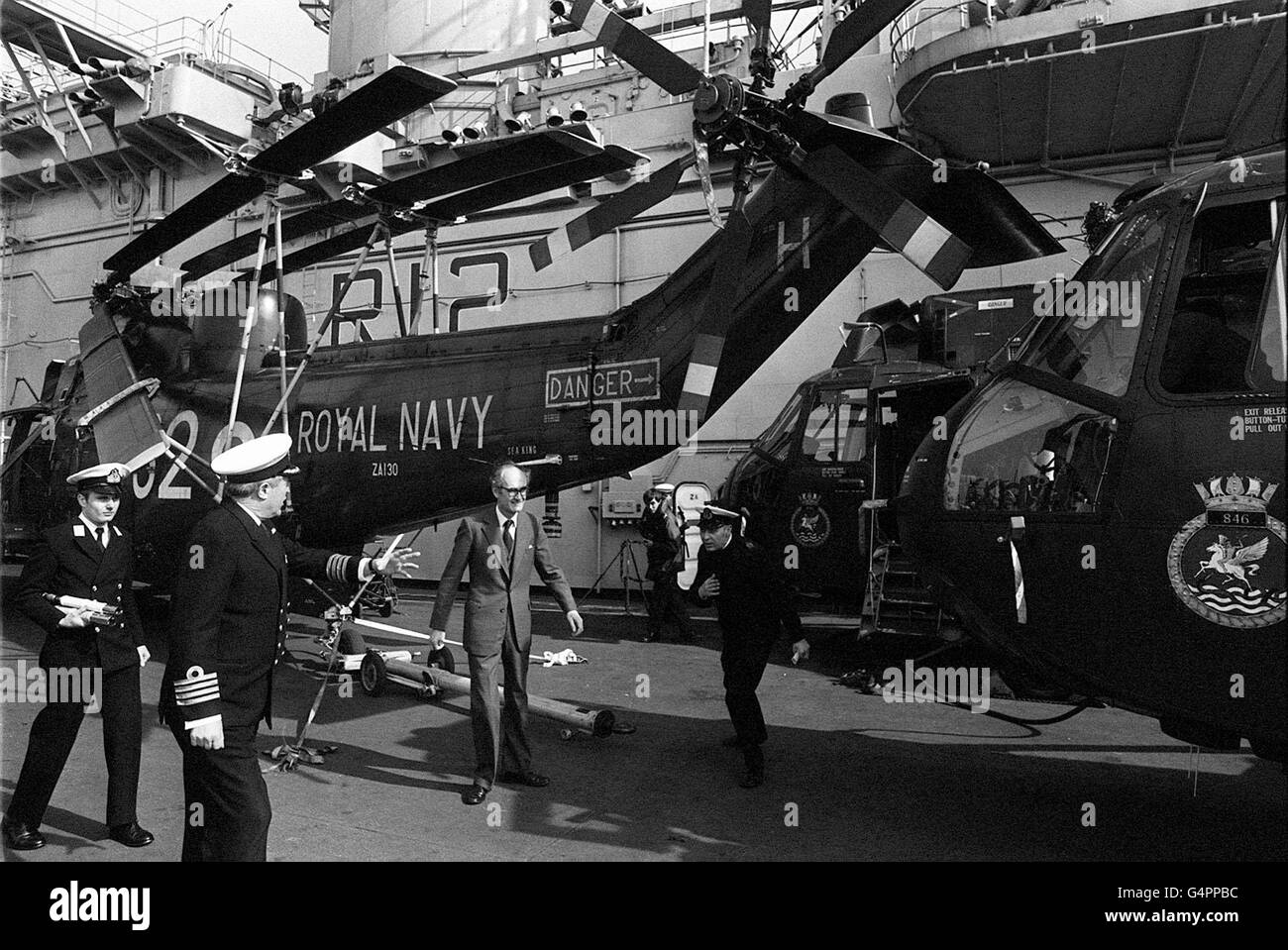 Verteidigungsminister John Mott kommt an einem Seemannshubschrauber an Bord der Fluggesellschaft HMS Hermes bei einer Inspektionsreise in Portsmouth vorbei. HMS Hermes wird Teil der Task Force für die Falklandfahrt sein. Stockfoto