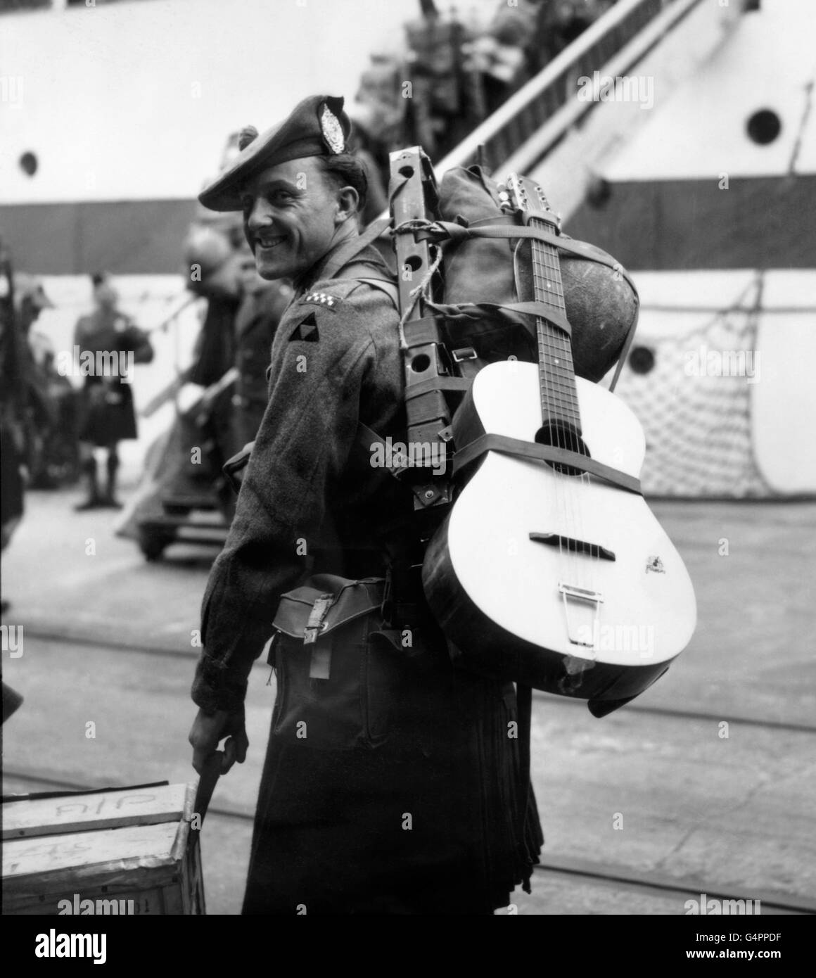 Der private T. Elwood aus Birmingham nahm seine Gitarre mit, als er auf dem Weg zum Mittelmeer an Bord des Troopschiffs SS Dilwara in Southampton ging. Stockfoto