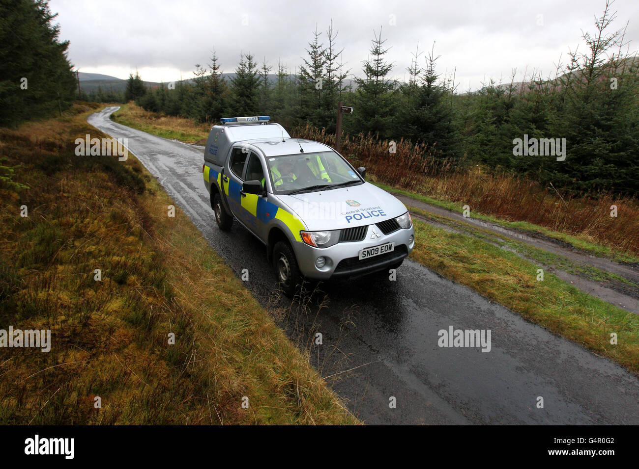 Central Scotland Polizeibeamte in einem Polizeiwagen an einer Straßensperre auf einer Landstraße in der Nähe des Carron Valley Reservoir in der Nähe von Fintry, Stirlingshire, in der Nähe des Fundort eines Mannes. Stockfoto