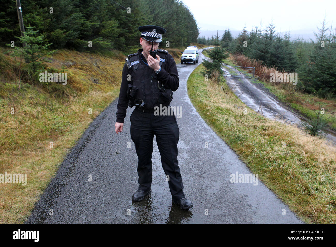Ein Beamter der Central Scotland Police steht an einer Straßensperre auf einer Landstraße in der Nähe des Carron Valley Reservoir in der Nähe von Fintry, Stirlingshire, in der Nähe des Fundort eines Mannes. Stockfoto