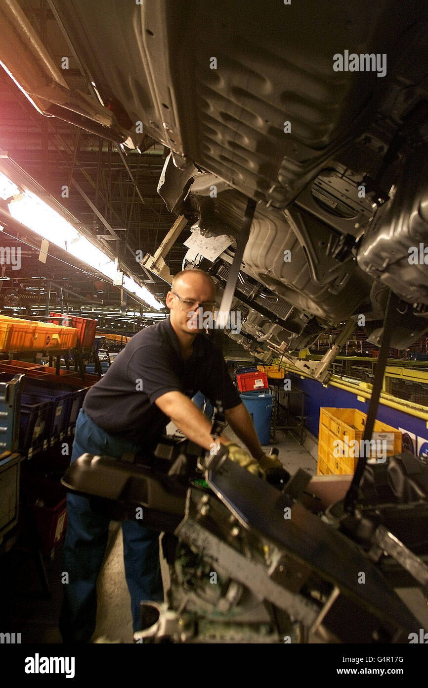 Nissan UK-Mitarbeiter sind an der Produktionslinie in seiner Fabrik in Sunderland im Einsatz. Laut einer Umfrage war das Nissan-Werk in Sunderland 1998 das produktivste Automobilwerk Europas. * seinen Arbeitnehmern wird nach der jährlichen Prüfung der Pkw-Produktion durch die Economist Intelligence Unit ein Aufkommen von 105 Autos pro Mitarbeiter gutgeschrieben, gegenüber 98 im Jahr 1997. Die Umfrage, die in der August-Ausgabe von Motor Business Europe veröffentlicht wurde, ergab, dass der Wearside-Standort in Bezug auf die Produktivität weltweit auf Platz 10 rangiert, wobei 288,838 1998 Fahrzeuge aus dem Werk rollten. Stockfoto