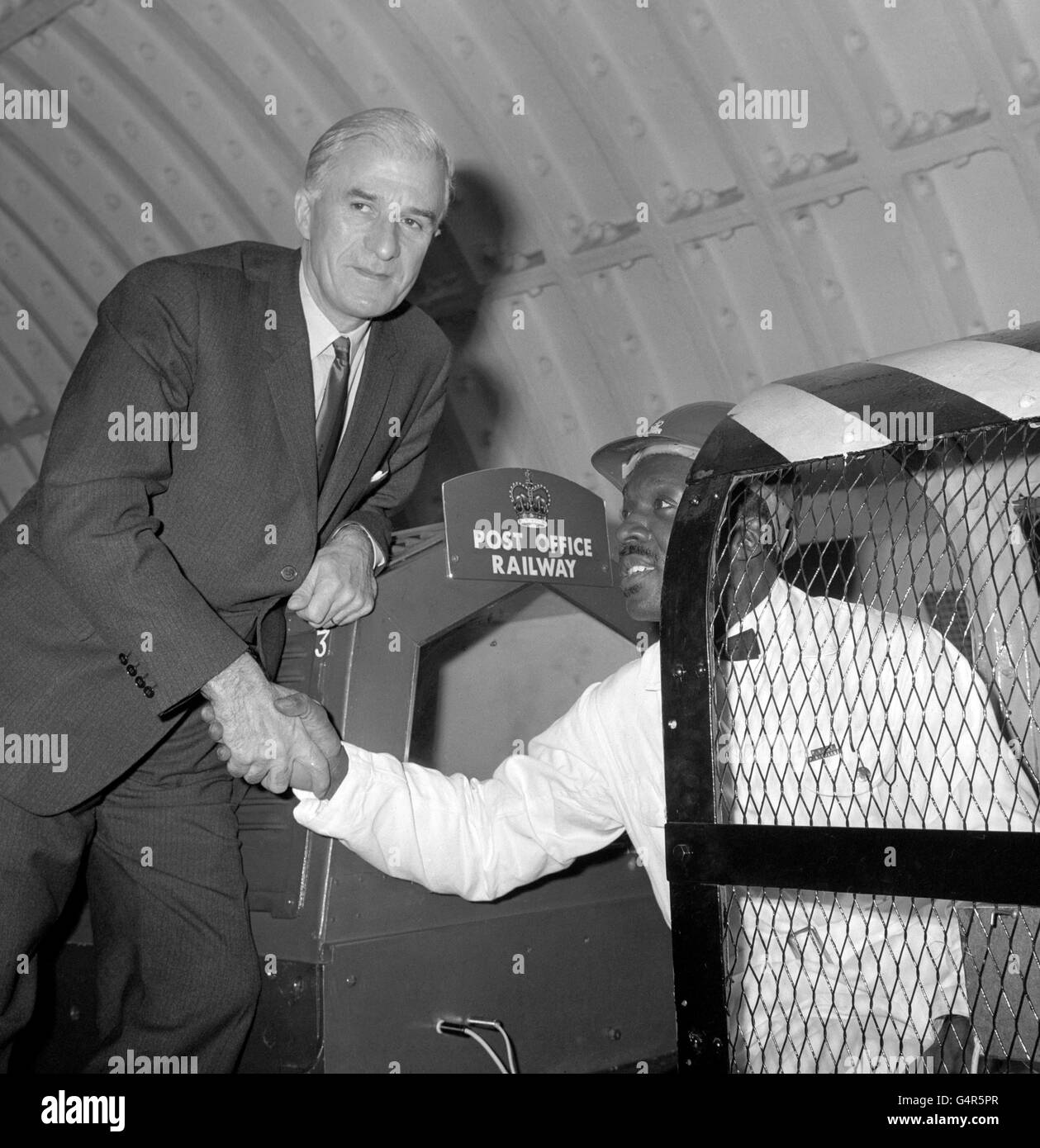 Postmeister General Edward Short (l) schüttelt sich die Hände der Wartungsarbeiten Postzugreiter Percell Richards aus Jamaika, nachdem er mit dem Postzug vom Mouth Pleasant Sorting Office zum Londoner Hauptbüro, King Edward Street, gefahren war. Stockfoto