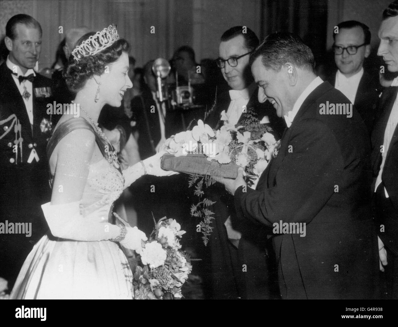 Königin Elizabeth II. Erhält nach einem Galakonzert in Amsterdam einen Blumenstrauß von Eduard van Beinum, dem Dirigenten des weltberühmten Concertgebouw-Orchesters der Niederlande. Der Herzog von Edinburgh sieht links zu. Stockfoto
