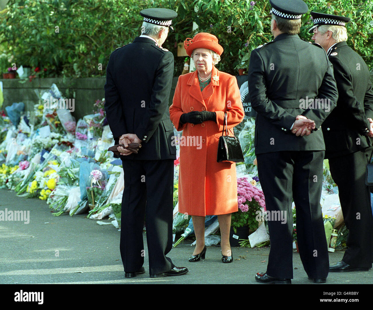 Großbritannien Königin Elizabeth II. Bei einem Besuch des Bahnabsturms Paddington in London, im Gespräch mit dem britischen Transport Police Chief Constable David Williams. Der Königin wurde der Punkt in Ladbroke Grove gezeigt, wo die beiden Züge kollidierten. * Sie verbrachte einige Minuten damit, sich die wachsende Sammlung von Blumengedenken zu betrachten, die von Menschen im Gedenken an die Opfer hinterlassen wurden. Stockfoto