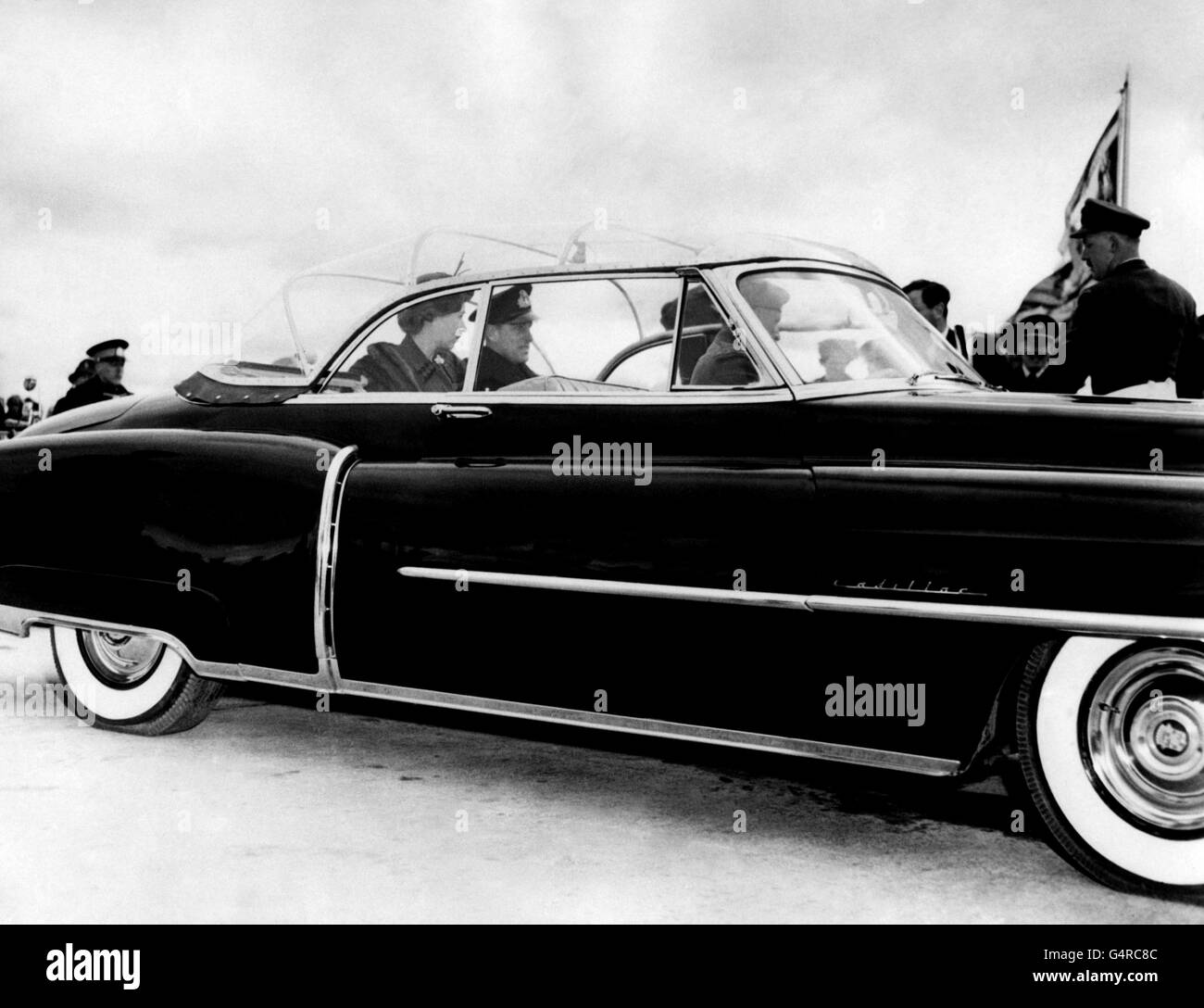 Der Herbst kann auf den kanadischen Prärien eine kalte Jahreszeit sein; zu kalt, um in einem offenen Auto gesehen zu werden. Auf der anderen Seite waren Tausende von Kanadiern Hunderte von Meilen nach Windnpeg, Manitoba, gekommen, um einen nicht zu vergessenden Blick auf Prinzessin Elizabeth und den Herzog von Edinburgh zu werfen, auf ihrer Königlichen Tour durch Kanada. So wurde das Problem gelöst, indem die königlichen Besucher gebeten wurden, in diesem speziell angefertigten Cadillac mit Plexiglas herum zu fahren, der hier durch die Straßen von Winnipeg fährt. Stockfoto