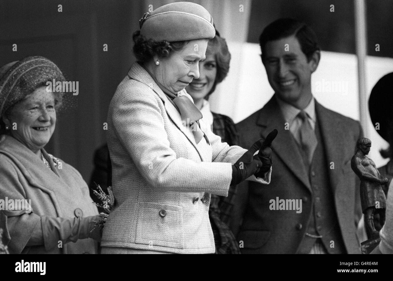 Ein klebriges Moment für Queen Elizabeth II, nachdem sie sich mit dem Schussputter Geoff Capes, der gerade das Rennen gewonnen hatte, die Hände schüttelte. Unfähig, das Harz zu waschen, verwendet, um Griff zu verbessern, aus seinen Händen, warnte er die Königin, was passieren könnte. Die Königin Mutter, Prinz von Wales und Prinzessin von Wales sehen die lustige Seite. Stockfoto