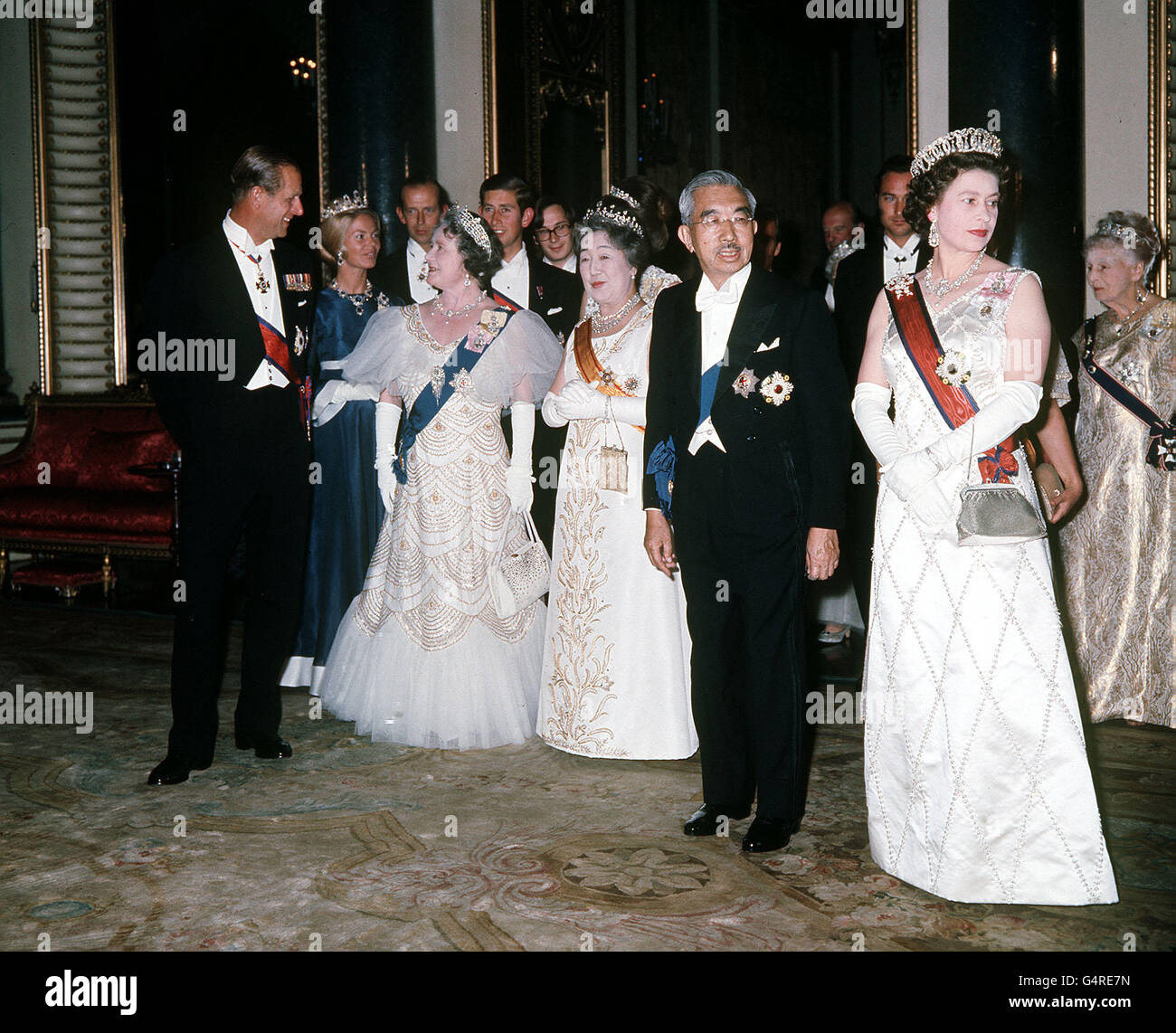 (L-R) der Herzog von Edinburgh, Königin Mutter, Kaiserin Nagako, Kaiser Hirohito und die Königin während eines Staatsbanketts im Buckingham Palast für den Kaiser von Japan. Von hinten (L-R): Die Herzogin von Kent, Herzog von Kent, Prinz von Wales, Prinzessin Anne (versteckt), Prinz William von Gloucester und Prinzessin Margaret (versteckt). Stockfoto