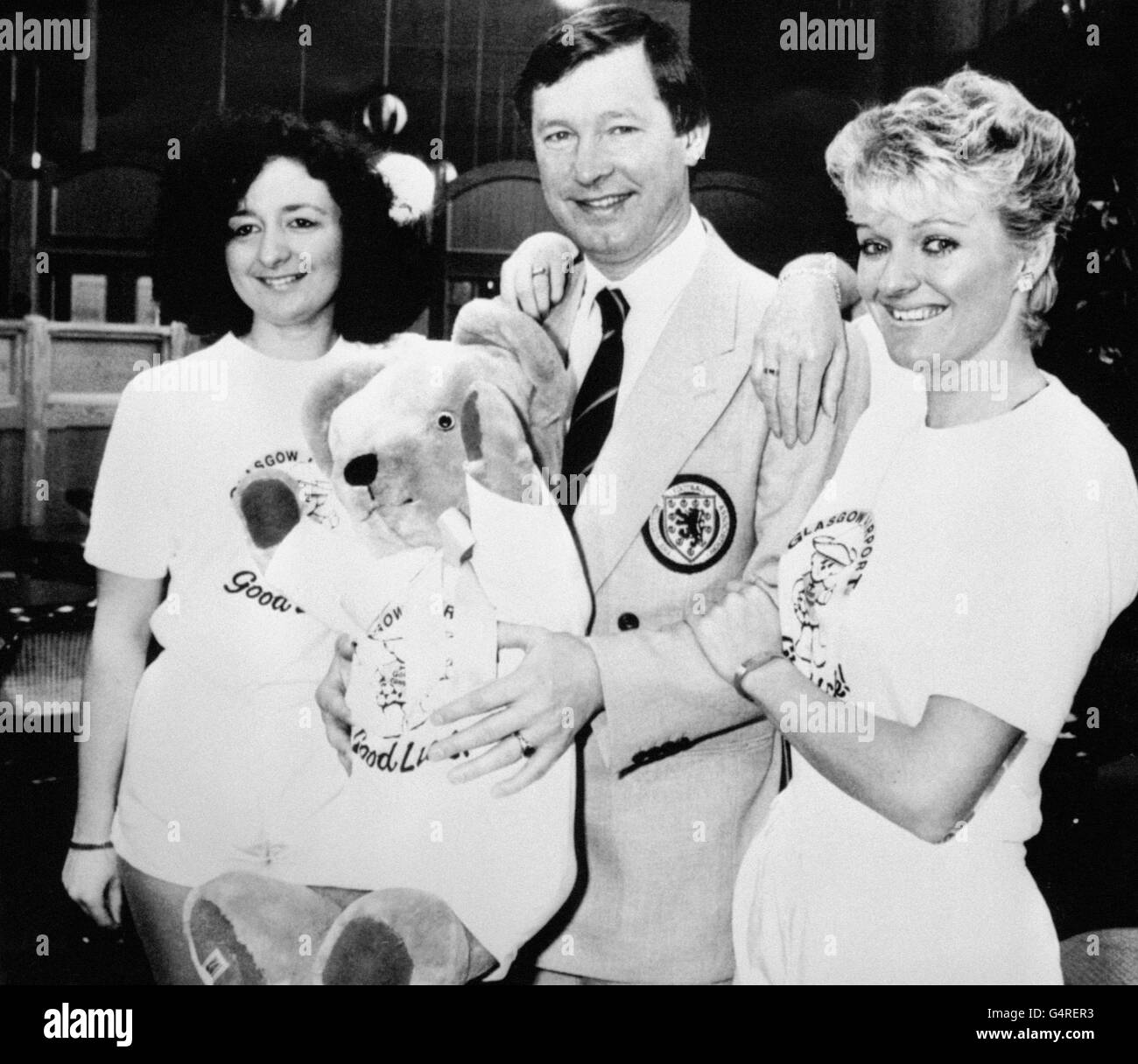 Schottland-Manager Alex Ferguson wünschte eine gute Reise durch Glasgow Airport Mitarbeiter, als sie ihm ein Maskottchen als er Mit dem Kader für die Weltmeisterschaft in Mexiko verlassen Stockfoto