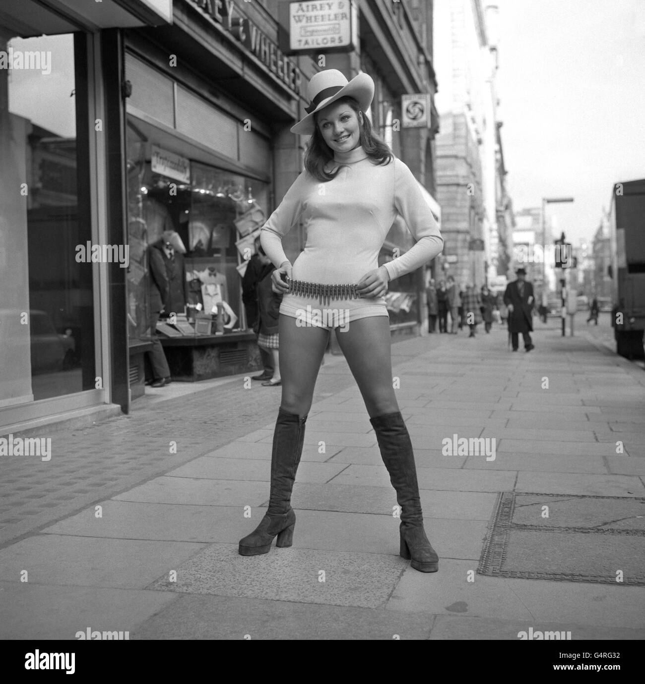 Miss Großbritannien, Carolyn Moore, in Piccadilly gesehen, trägt einen beigen Jump-Anzug, braune Wildlederstiefel und breitkrempigen Hut. Sie trug dieses modische Kleid, um eine Funktion des Milch Marketing Board zu besuchen. Stockfoto
