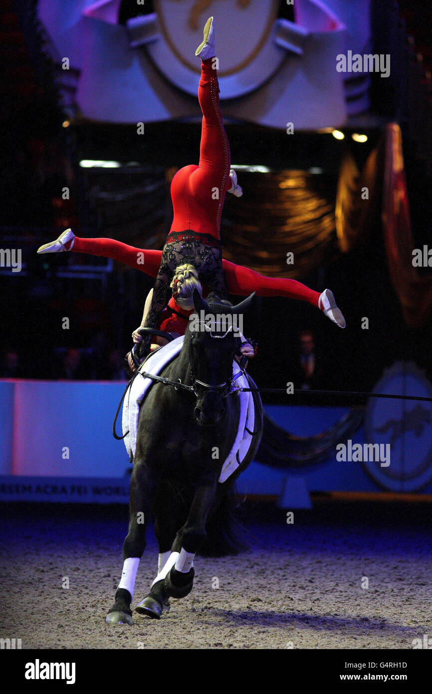 Die Eccles-Familie aus Glasgow, bestehend aus Vater John und seinen Töchtern Joanne und Hannah, führen während der London International Horse Show im Olympia, London, eine Demonstration auf Vaulting durch. Stockfoto Die Eccles-Familie aus Glasgow, bestehend aus Vater John und seinen Töchtern Joanne und Hannah, führen während der London International Horse Show im Olympia, London, eine Demonstration auf Vaulting durch. Stockfoto