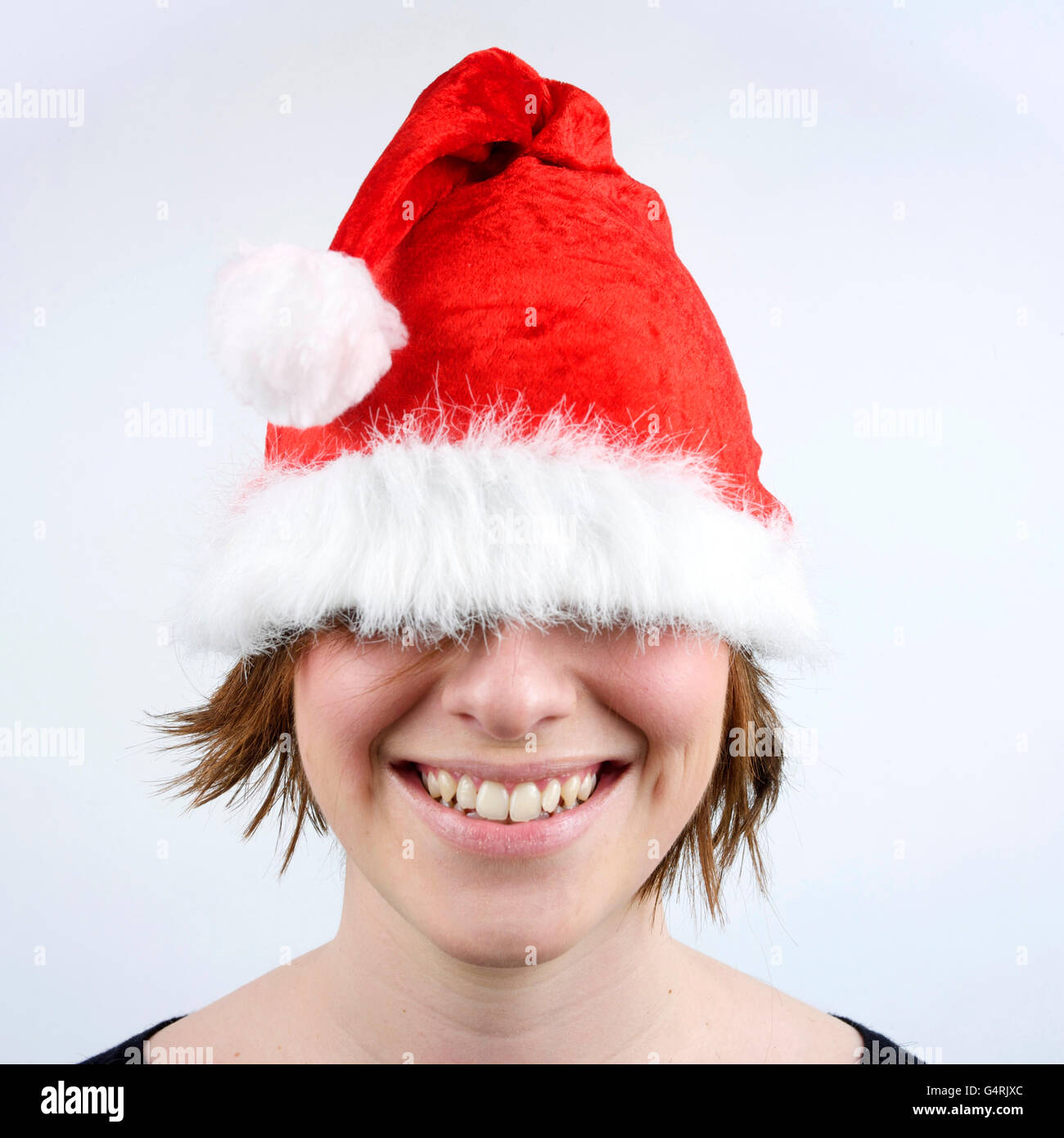 Junge Frau trägt Weihnachtsmütze für ihre Augen Stockfoto