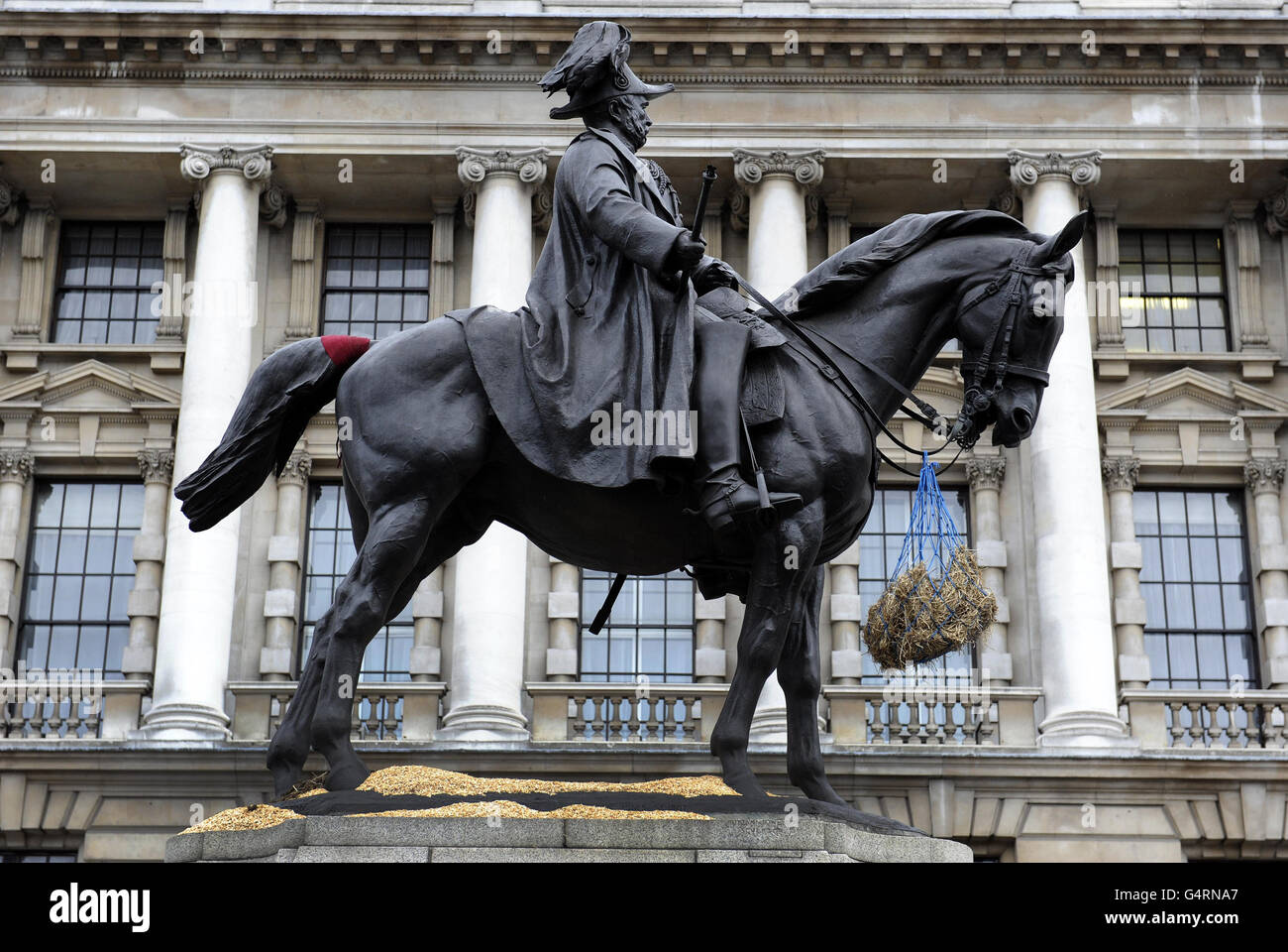 An einer Statue des Feldmarschalls, seiner Königlichen Hoheit George, Duke of Cambridge, Oberbefehlshaber der Britischen Armee 1856-1895 in Whitehall, London, ist ein Sack Heu und Sägemehl zu sehen. Stockfoto