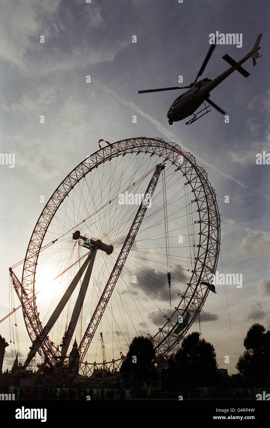 Ein Polizeihubschrauber wird verwendet, um mit Demonstranten der baskischen Gruppe Solidarios con Itoitz und der indischen Gruppe Narmada UK auf dem neu errichteten 450 Meter hohen London Eye-Riesenrad an der Themse in London zu sprechen. * bis zu zehn Aktivisten, die der Sicherheit auswichen, bevor sie das Rad bestiegen und Banner gegen den Bau von Dämmen im Baskenland in Spanien und in Indien enthüllten. Das 1,500-Tonnen-Millenium-Rad, wurde schließlich in eine aufrechte Position am Südufer der Themse Anfang dieses Monats gezogen. Es bietet einen spektakulären Blick über die Hauptstadt und wird eröffnet Stockfoto