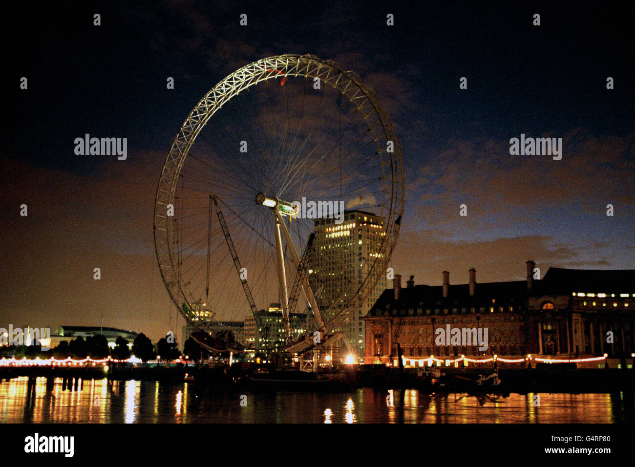 Zwei Demonstranten (gekennzeichnet durch eine rote Flagge) bleiben an der Spitze des 450 Fuß großen Millennium Wheel in London angekettet. Die beiden waren ursprünglich Teil einer Gruppe, die der Sicherheit auswich, um das 1,500-Tonnen-Gebäude zu skalieren, als Protest gegen den Bau von Staudämmen in Spanien und Indien. *die Demonstranten stammen von der baskischen Umweltschützergruppe Solidarios con Itoitz und der indischen Gruppe Narmada UK. Stockfoto