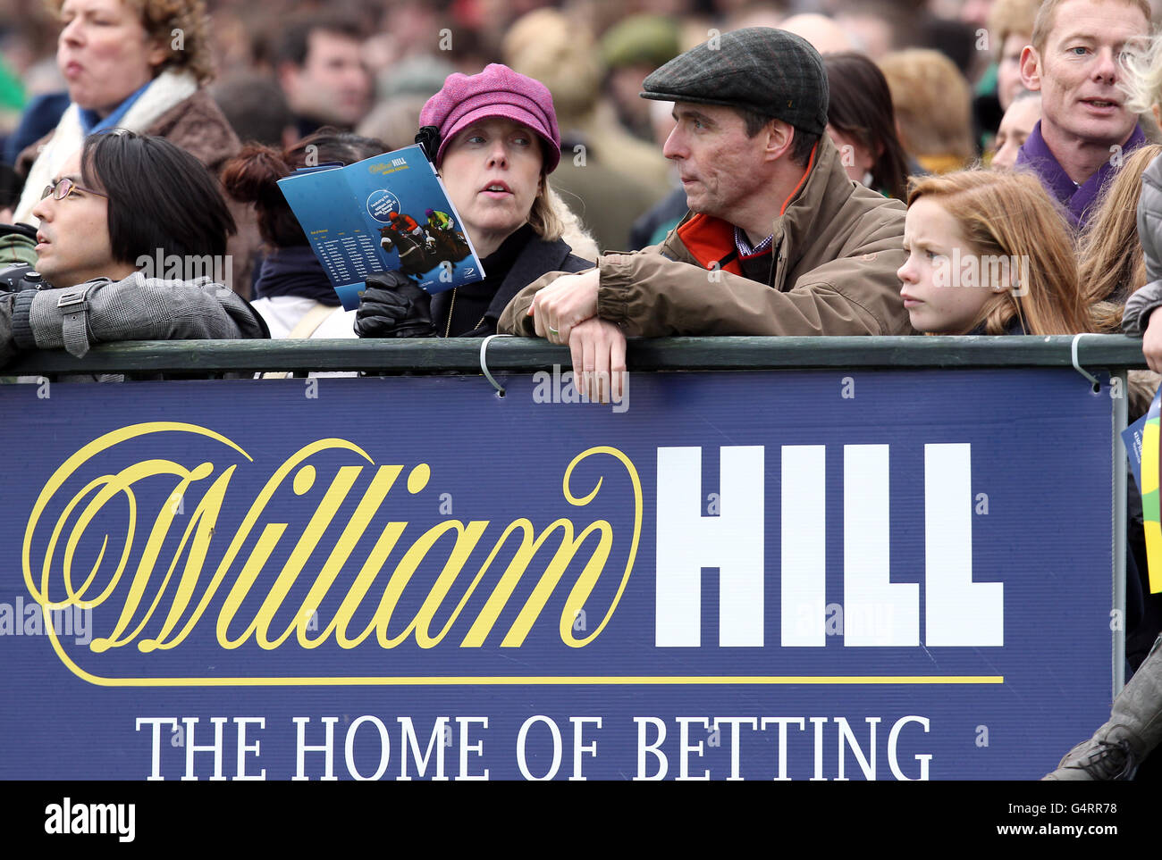 Racegoers sehen an, wie ein Pferd um den geführt wird Paradekranz Stockfoto