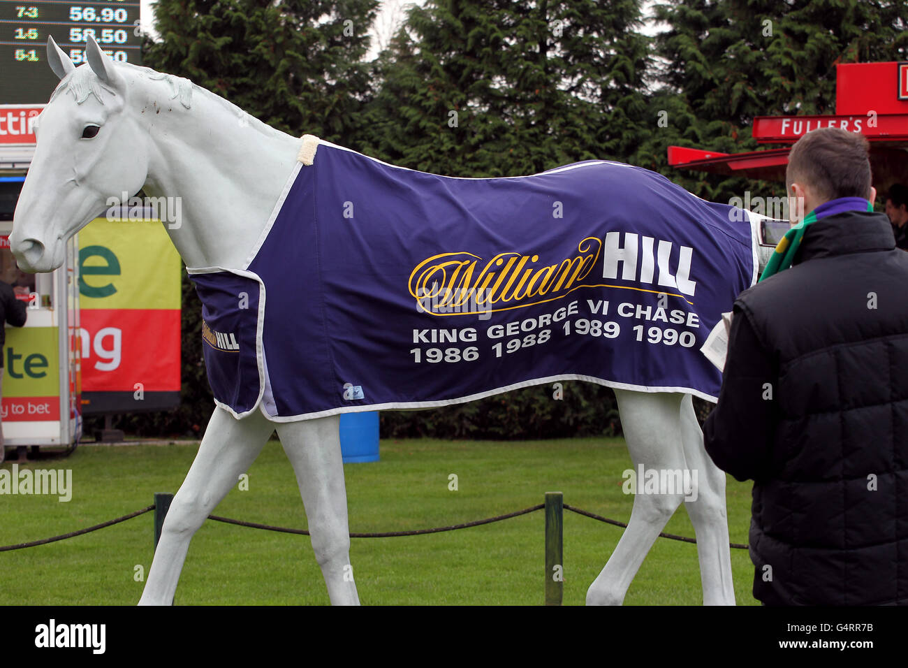 Pferderennen - The William Hill Winter Festival 2011 - King George VI Steeple Chase - Kempton Park. Statue mit William Hill Branding und einem Rennfahrer im Kempton Park Stockfoto