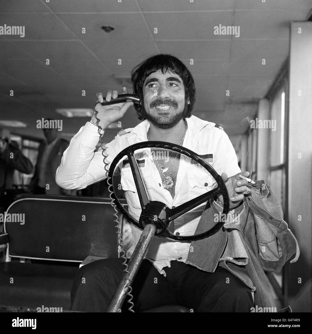 Keith Moon, Schlagzeuger der Popband The Who, nimmt am Londoner Flughafen Heathrow das Steuer eines Gepäcktransporters am Flughafen in die Rolle. Er flog von LA, um sich der Gruppe für eine Tour durch England und Frankreich anzuschließen. Stockfoto