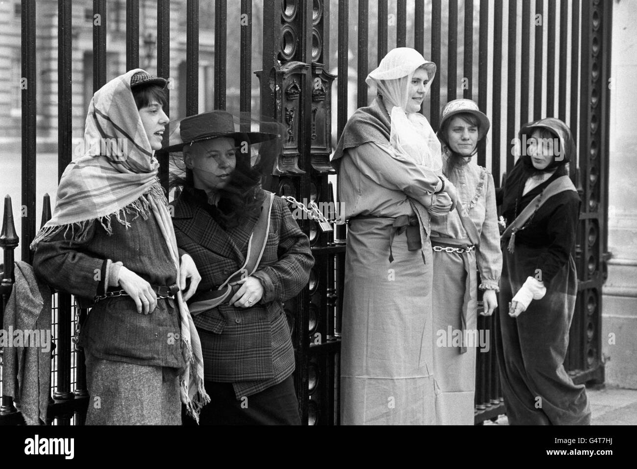 Demonstranten in Suffragette-Kleidung ketten sich an die Tore vor dem Buckingham Palace in London, um gegen die Pläne der Regierungen zu protestieren, den lokalen Behörden die Förderung von Homosexualität zu verbieten. Stockfoto