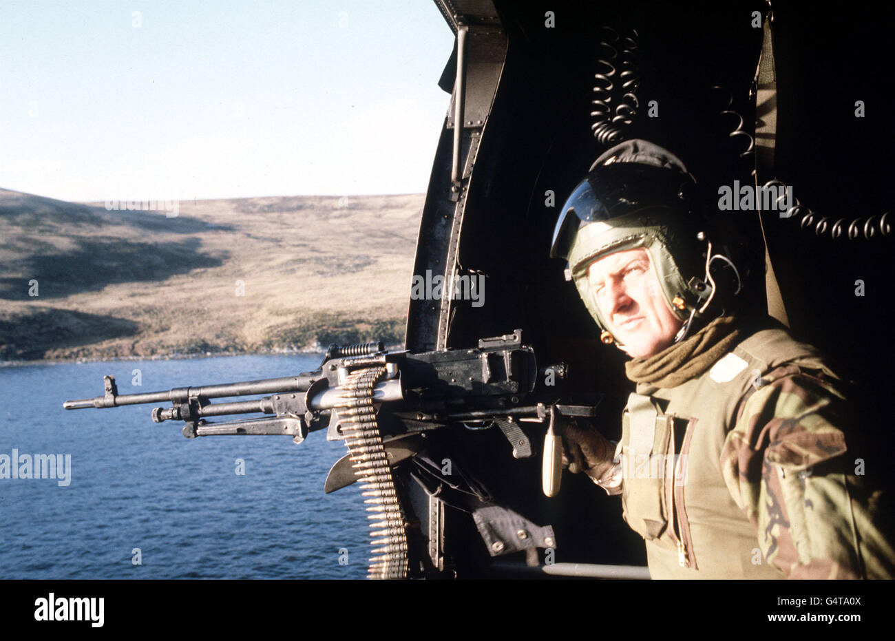 Der Falkland-Krieg: Ein Besatzungsmann bemannt ein Mehrzweck-Maschinengewehr, das im Schlupfweg eines Hubschraubers auf Patrouille über San Carlos Wasser während des Falkland-Konflikts montiert ist. Stockfoto