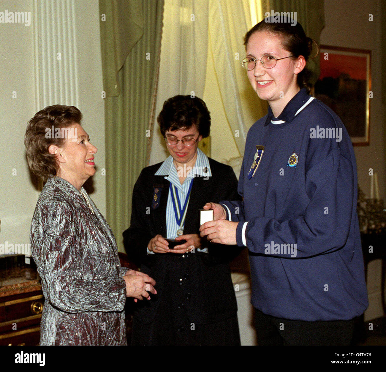 Die Schwester der Königin, Prinzessin Margaret (links), begrüßt als Präsidentin der Guides Association die Mädchen-Führerin Becky South (rechts) im Kensington Palace, London. HRH überreichte ein Abzeichen, das von einer Gruppe, deren Mitglied sie war, zum Anlass des Millenniums ausgewählt wurde. * ein Teil der Einnahmen aus dem Verkauf der Abzeichen wird das Projekt Book Aid Service unterstützen, was der Kinderkompetenz in Afrika zugute kommt. (l/r) Prinzessin Margaret, Bridget Towle, Chief Guide, und Becky South, aus Harrogate, nordostengland. Stockfoto