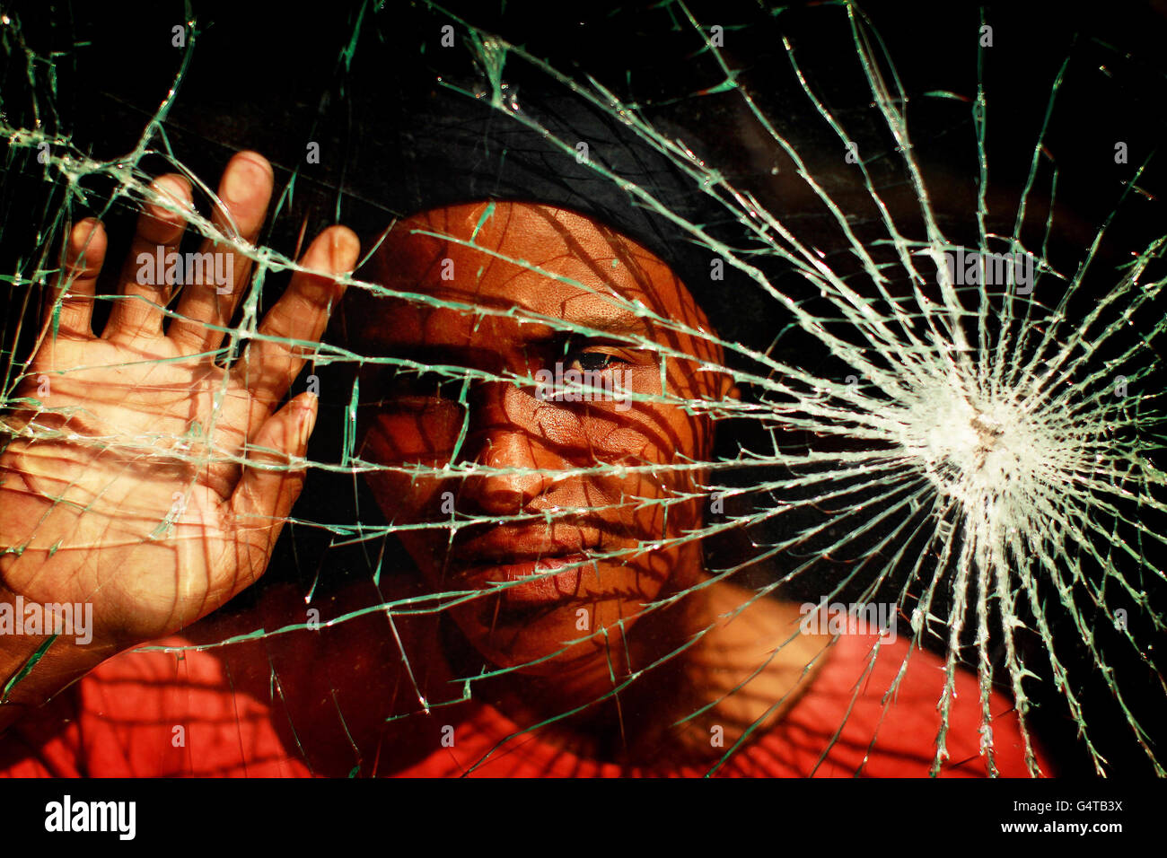 Iris Davids, die durch ihr zerstörtes Barackenfenster in der Blikkiesdorp Township in Kapstadt, Südafrika, fotografiert wurde, weil die Kluft zwischen Arm und Reich in Südafrika zu stark ist, warnte eine ehemalige Hochkommissarin der Vereinten Nationen für Menschenrechte. Stockfoto