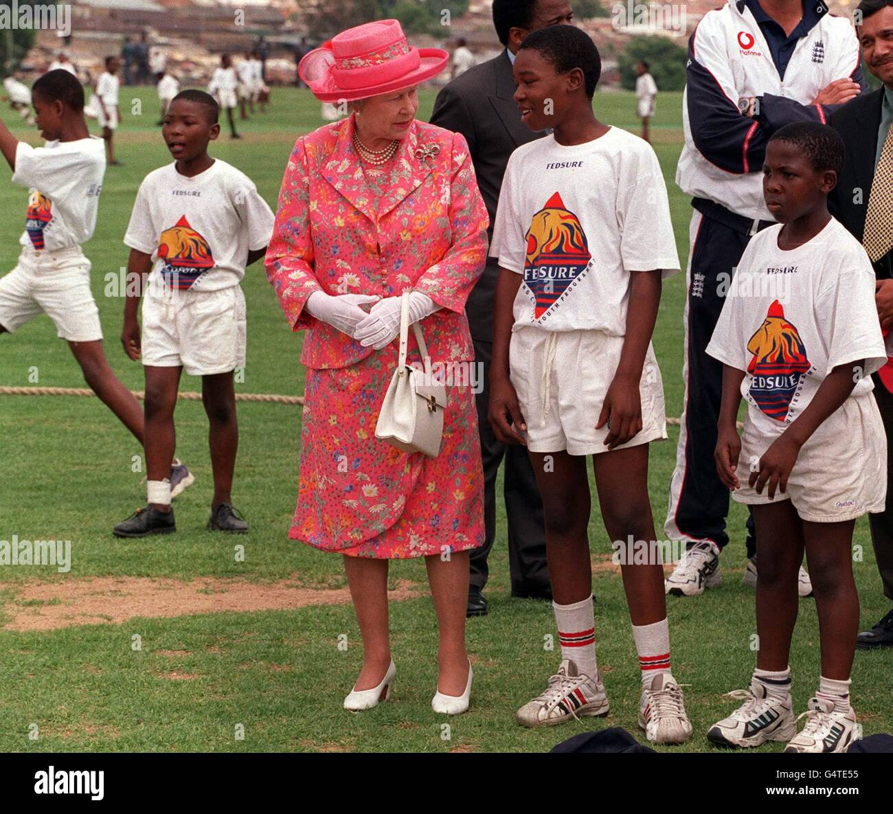 Die Königin spricht mit jungen Cricketspielern, während sie den Kricketplatz Alexander Township nördlich von Johannesburg, Südafrika besucht. Die Königin ist vor dem Treffen der Regierungschefs des Commonwealth in Durban auf Staatsbesuch. Stockfoto