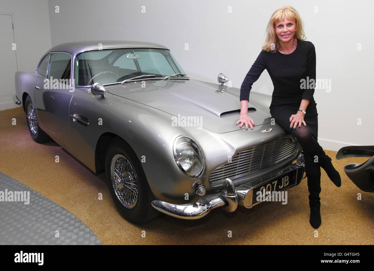 Das ehemalige Bond-Mädchen Britt Ekland sitzt auf der Motorhaube des ursprünglichen Aston Martin DB5 bei einer neuen Ausstellung, Bond in Motion, im National Motor Museum, Beaulieu im New Forest, Hampshire. Stockfoto