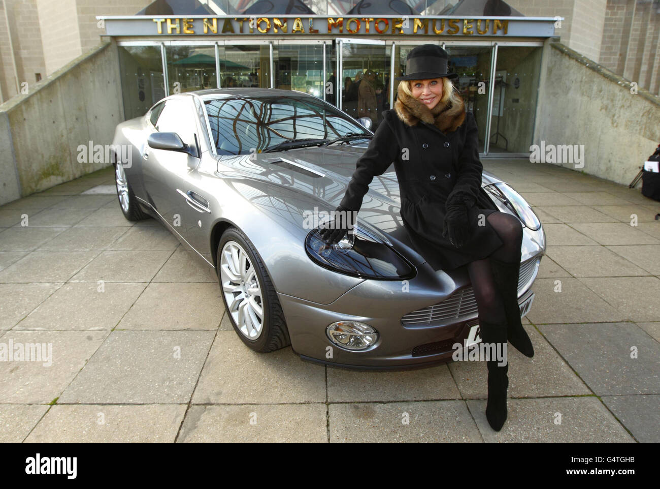 Das ehemalige Bond-Mädchen Britt Ekland sitzt auf der Motorhaube eines Aston Martin bei der neuen Ausstellung Bond in Motion im National Motor Museum, Beaulieu im New Forest, Hampshire. Stockfoto