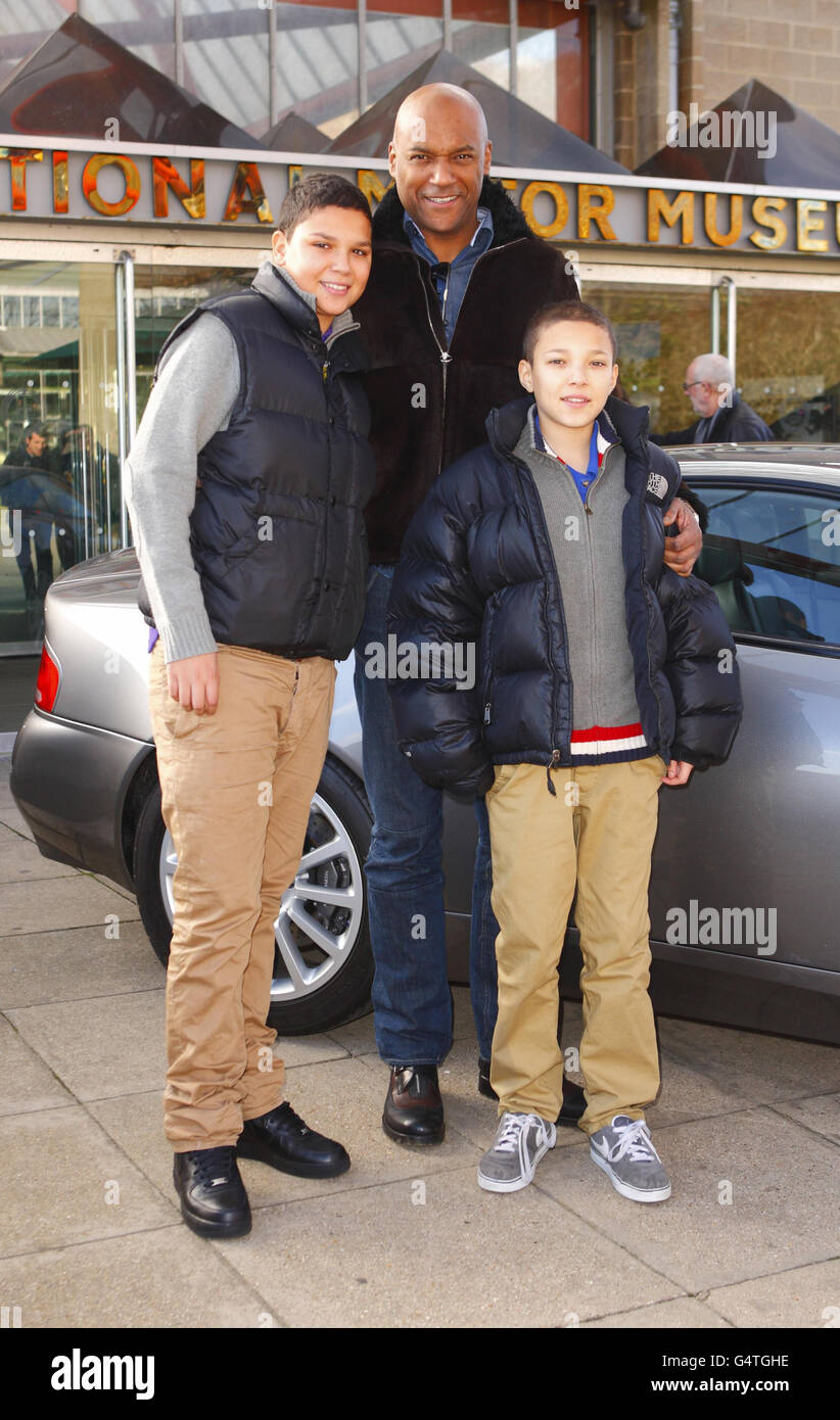 Bond-Schauspieler Colin Salmon mit den Söhnen Eden (links) und Benjamin bei der neuen Ausstellung Bond in Motion im National Motor Museum, Beaulieu im New Forest, Hampshire. Stockfoto