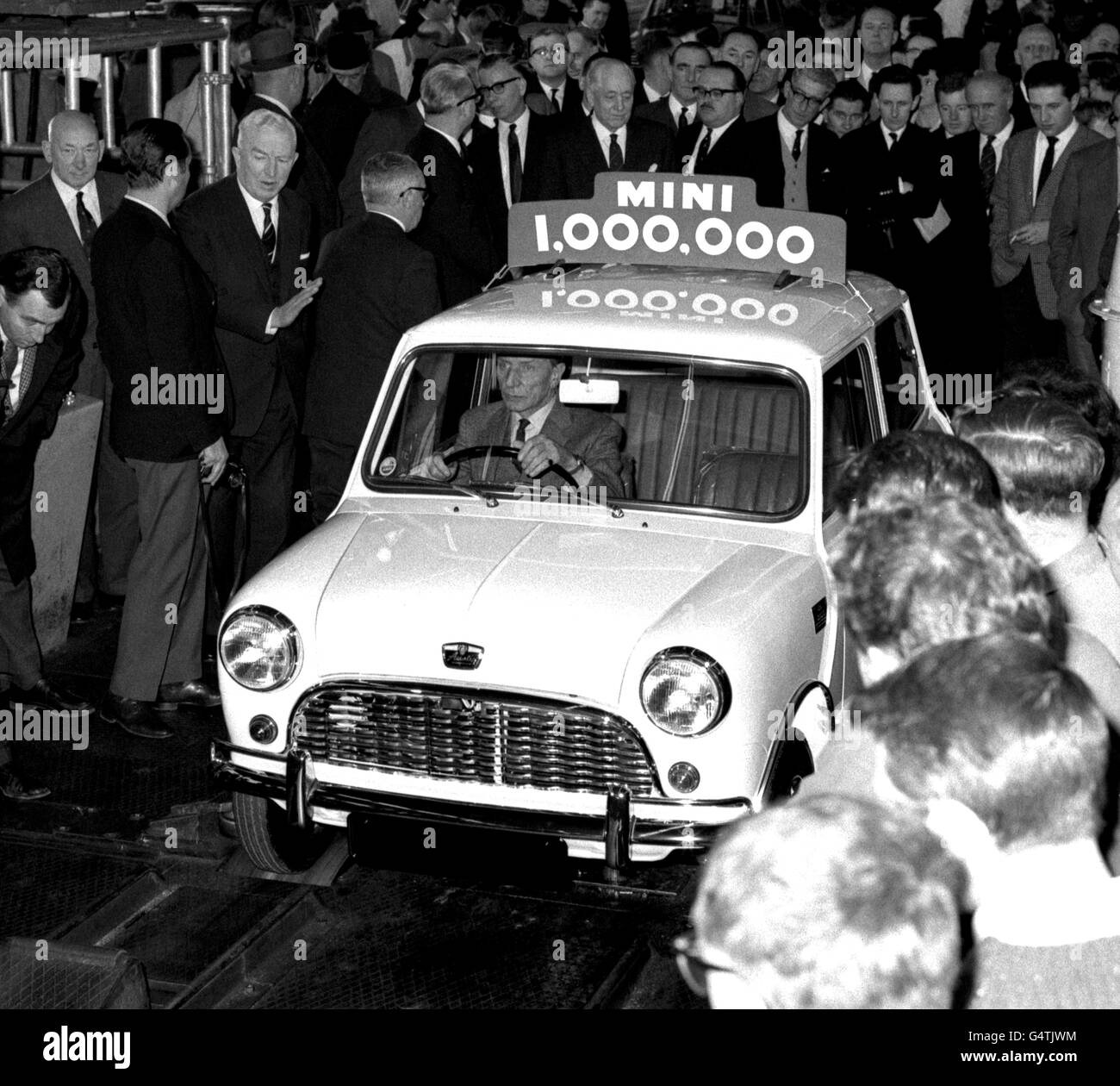 Alec Issigonis, Schöpfer der „Mini“-Automobilreihe der British Motor Corporation, fährt den 1.000.000sten Mini vom Band im Werk Austin in Longbridge, Birmingham. *27/02/01 der neue Mini, der im Sommer 2001 in Großbritannien zum Verkauf kommen wird, wurde zum ersten Mal vorgestellt. Der in Oxford gebaute 1.6-Liter-Wagen feierte seine Weltpremiere auf dem Genfer Automobilsalon. Mit Zentralverriegelung, Antiblockiersystem, einem Sound-System mit sechs Lautsprechern und elektrischen Fenstern ist der neue Mini weit entfernt vom ersten seiner Art aus dem Jahr 1959. Stockfoto