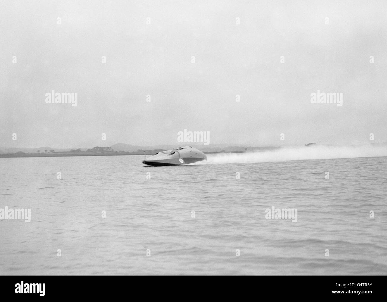 Sir Malcolm Campbell bei der Kontrolle seines neuesten Jet-Propellers Bluebird während eines Testlaufs über die ruhigen Gewässer von Poole Harbour Stockfoto