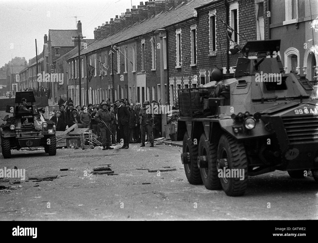In der Disraeli Street spricht ein protestantisch-Geistlicher mit einem Soldaten in der Nähe eines gepanzerten Autos, kurz nachdem Truppen zum ersten Mal in das protestantische Gebiet von Belfast eingezogen waren. Truppen, die eine Haus-zu-Haus-Suche durchgeführt haben, entdeckten eine Menge von Benzinbomben. Stockfoto