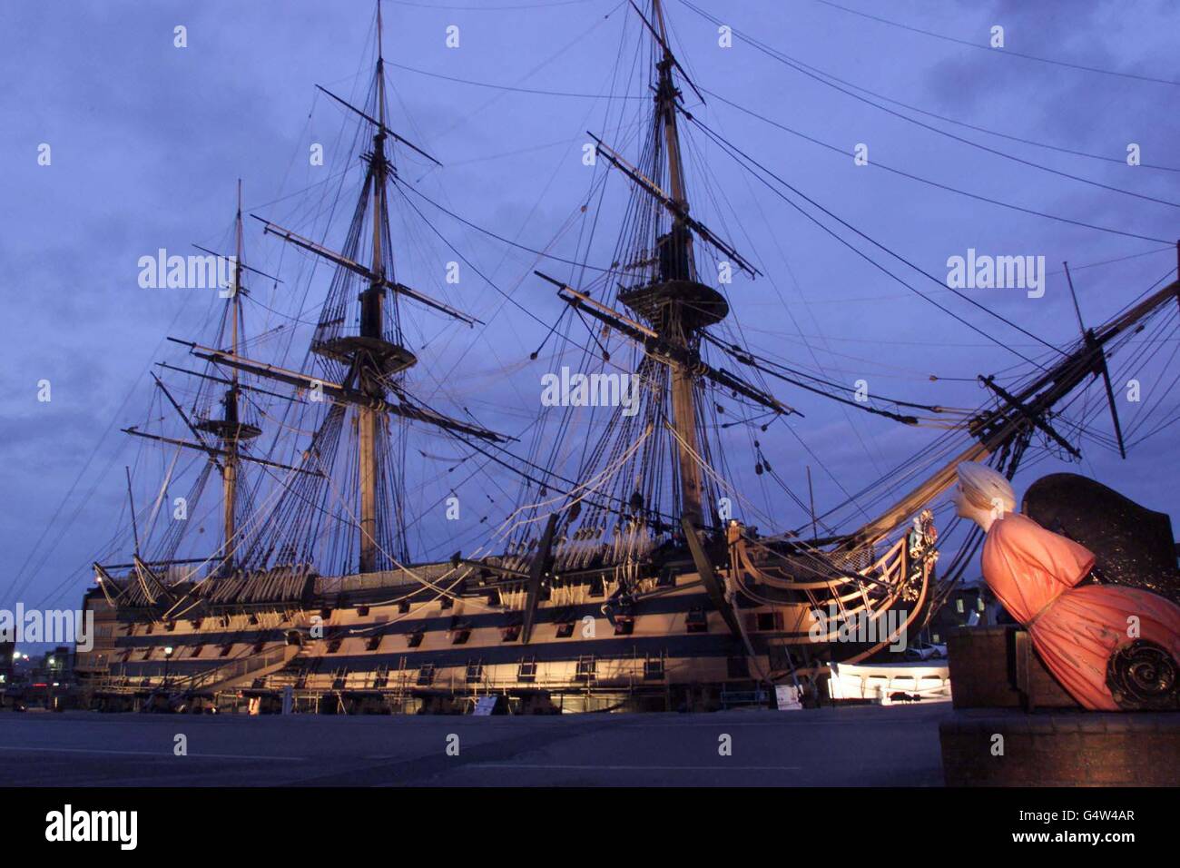 Neue Beleuchtungen beleuchten die HMS Victory in Portsmouth historischer Schiffswerft. Die Lichter wurden im Rahmen der Jahrtausendrenovierung des 900 Jahre alten Marinestützpunktes installiert. 19/05/04: Holz aus 200 Jahre alten Eichen, die auf Befehl des Premieradmirals der Royal Navy, Lord Nelson, angebaut wurden, wurde heute für die Restaurierung seines Flaggschiffs HMS Victory transportiert. Stockfoto