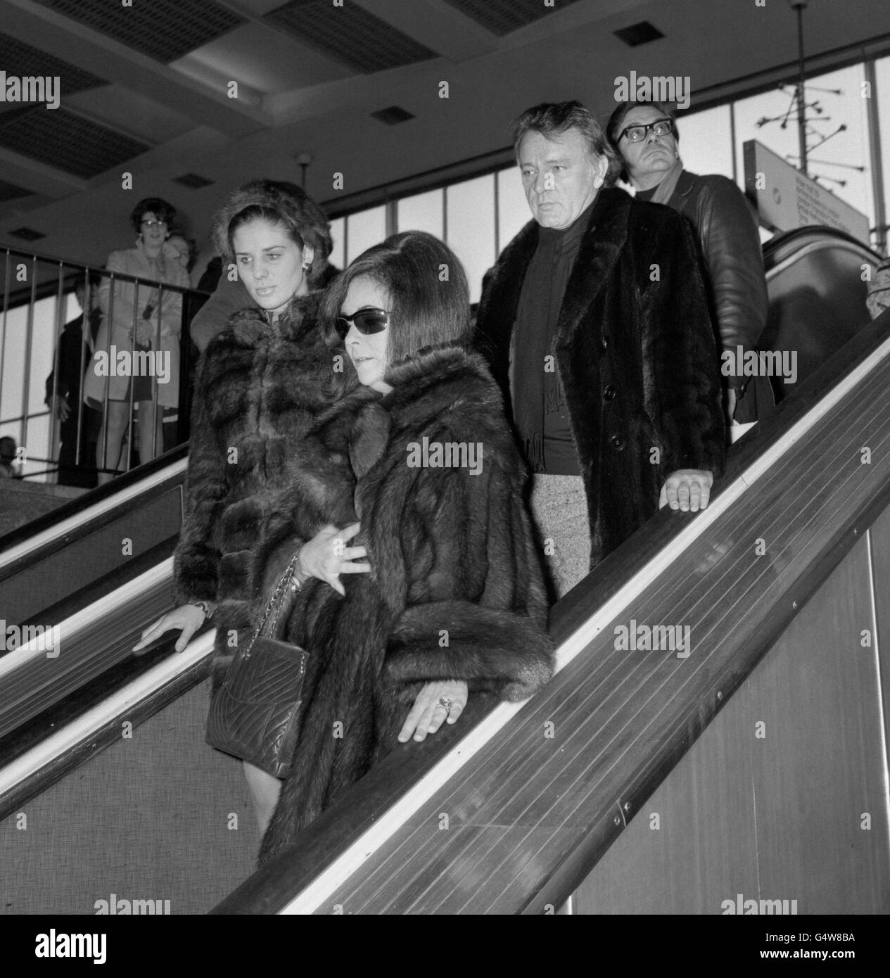 Die mit Mink bekleideten Filmstars Elizabeth Taylor und ihr Mann Richard Burton kommen am Flughafen Heathrow an. Sie flogen an Bord eines privaten Executive-Jet-Flugzeugs und sind in London, um an der heutigen Gala-Premiere von Richard Burtons neuestem Film „Where Eagles Dare“ teilzunehmen, der in Anwesenheit von Prinzessin Alexandra im Empire Theatre gezeigt wird. Die Premiere unterstützt den Richard Burton Haemophilia Appeal Fund. Stockfoto