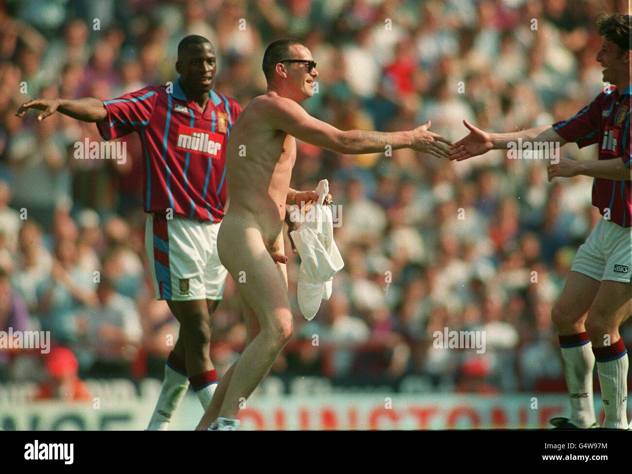 Soccer - Aston Villa gegen Liverpool. Andy Townsend von Aston Villa begrüßt einen Streaker auf dem Spielfeld Stockfoto